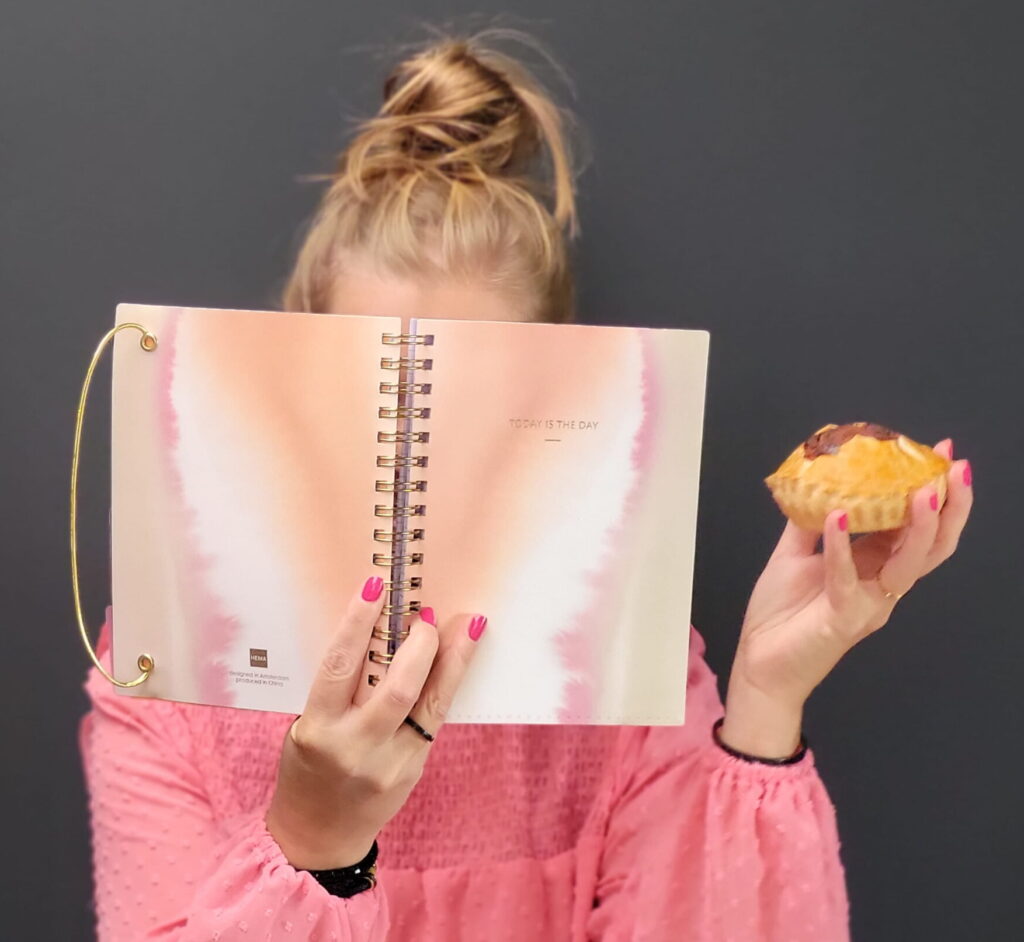 Hands-on Hero Ilse met dotje achter notebook en met mattentaartje in de hand